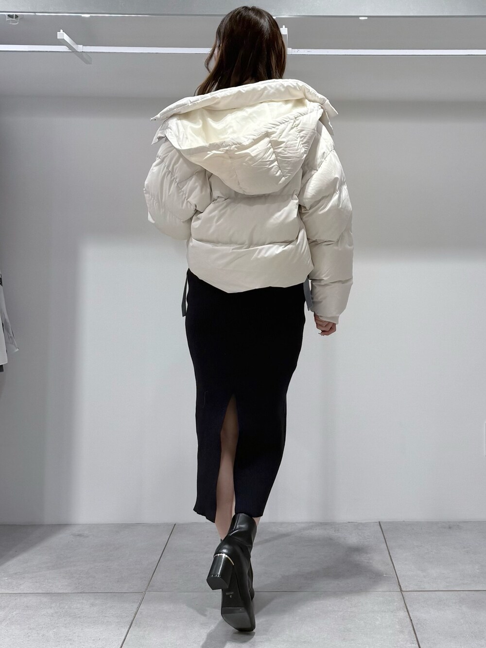 ホワイト系のダウンジャケット/コート、ブルー系のワンピース、ブラック系のブーツを着用したレディースの冬コーディネートの3枚目の写真