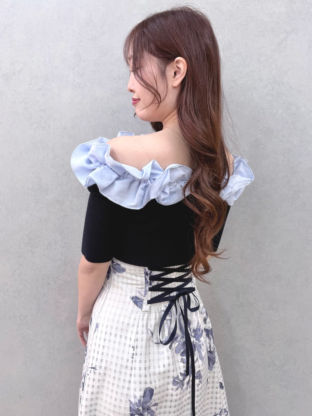 ブルー系のニット/セーター、ブルー系のスカート、シルバー系のサンダルを着用したレディースの春コーディネートの5枚目の写真