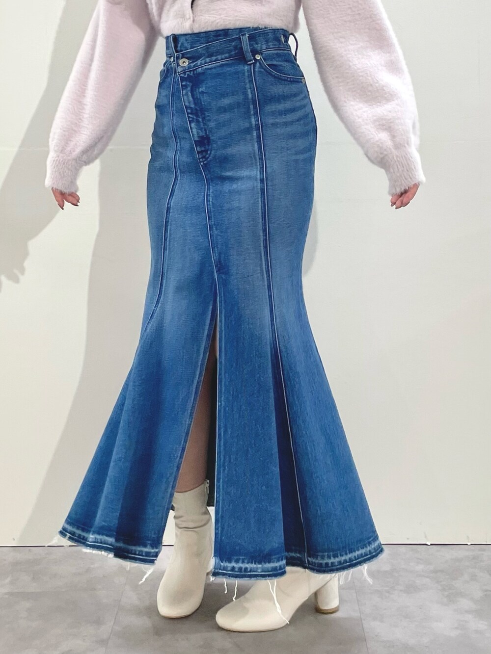 ピンク系のカーディガン/ボレロ、ブルー系のスカート、ホワイト系のブーツを着用したレディースの冬コーディネートの7枚目の写真