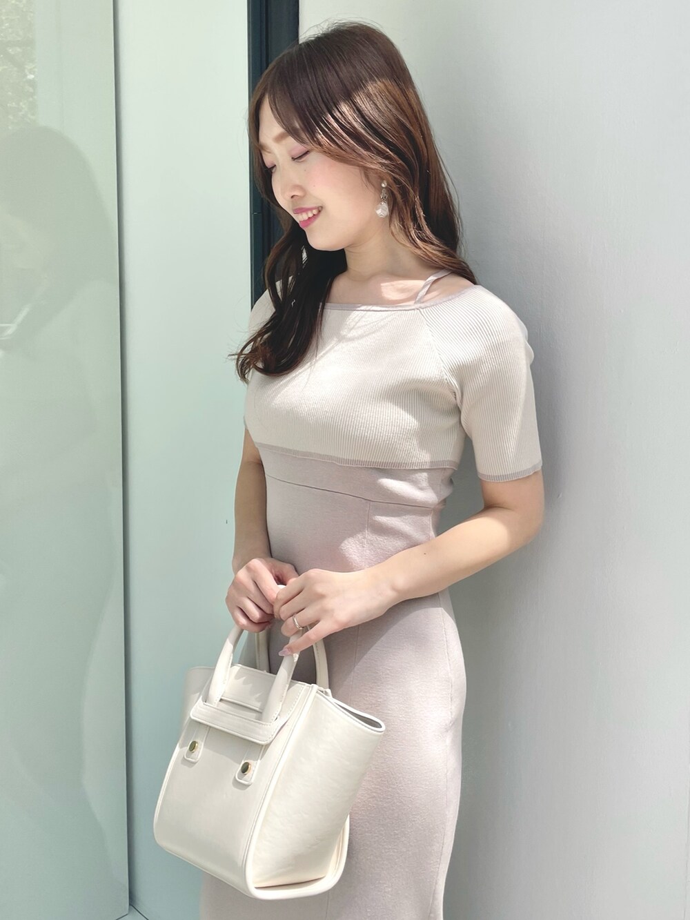 ブラウン系のブーツ、ピンク系のワンピース、ホワイト系のトートバッグを着用したレディースの春コーディネートの4枚目の写真