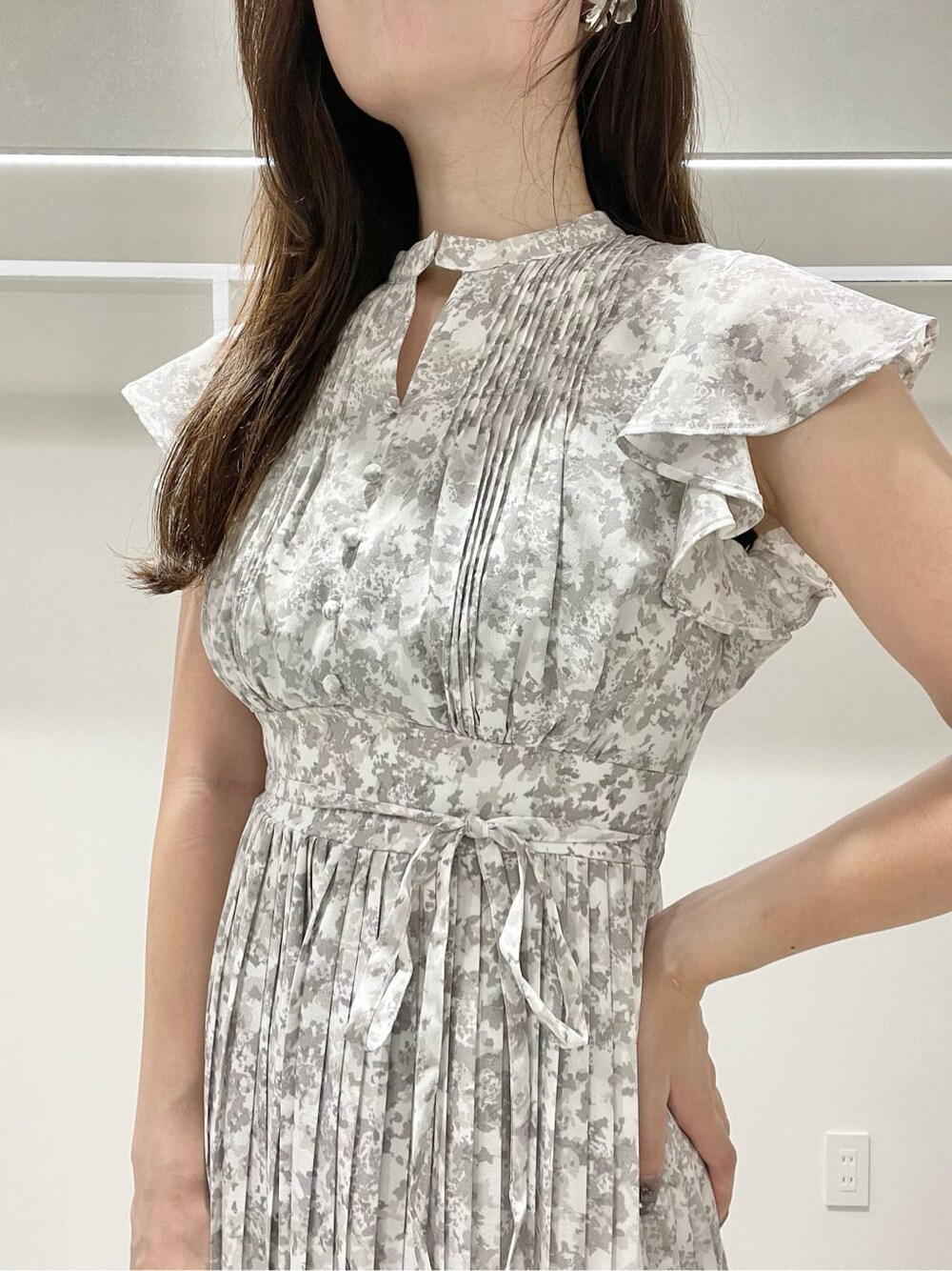 グリーン系のサンダル、グレー系のワンピース、シルバー系のイヤリングを着用したレディースの夏コーディネートの4枚目の写真