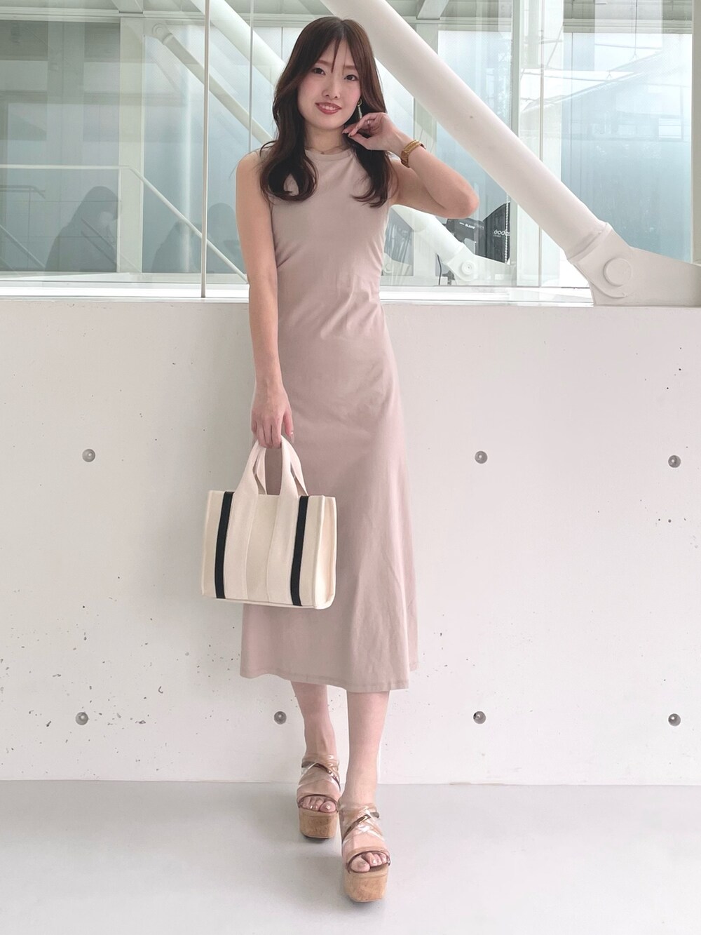 ホワイト系のハンドバッグ、ブラウン系のサンダル、ベージュ系のワンピースを着用したレディースの春コーディネートの2枚目の写真