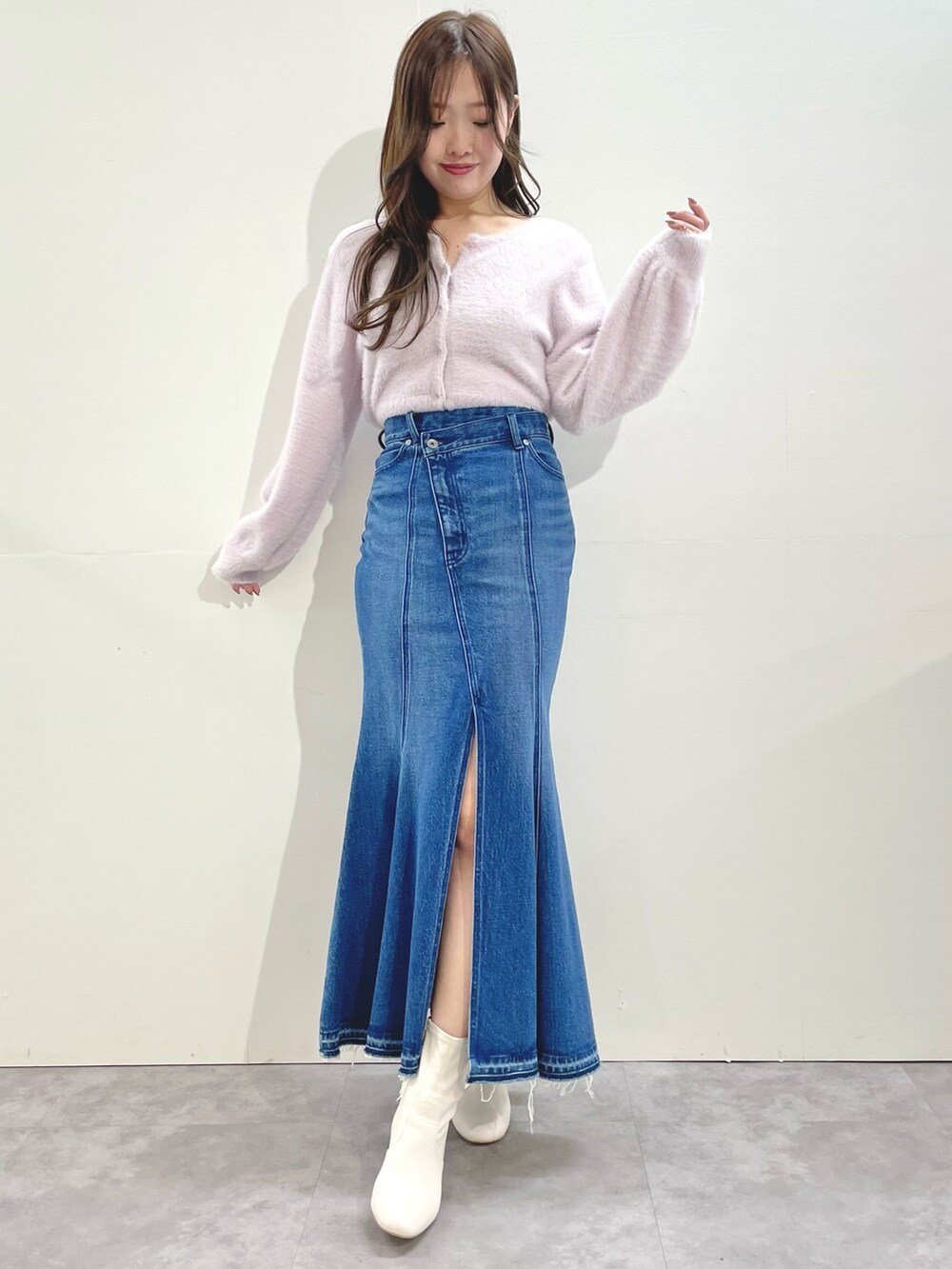 ピンク系のカーディガン/ボレロ、ブルー系のスカート、ホワイト系のブーツを着用したレディースの冬コーディネートの4枚目の写真