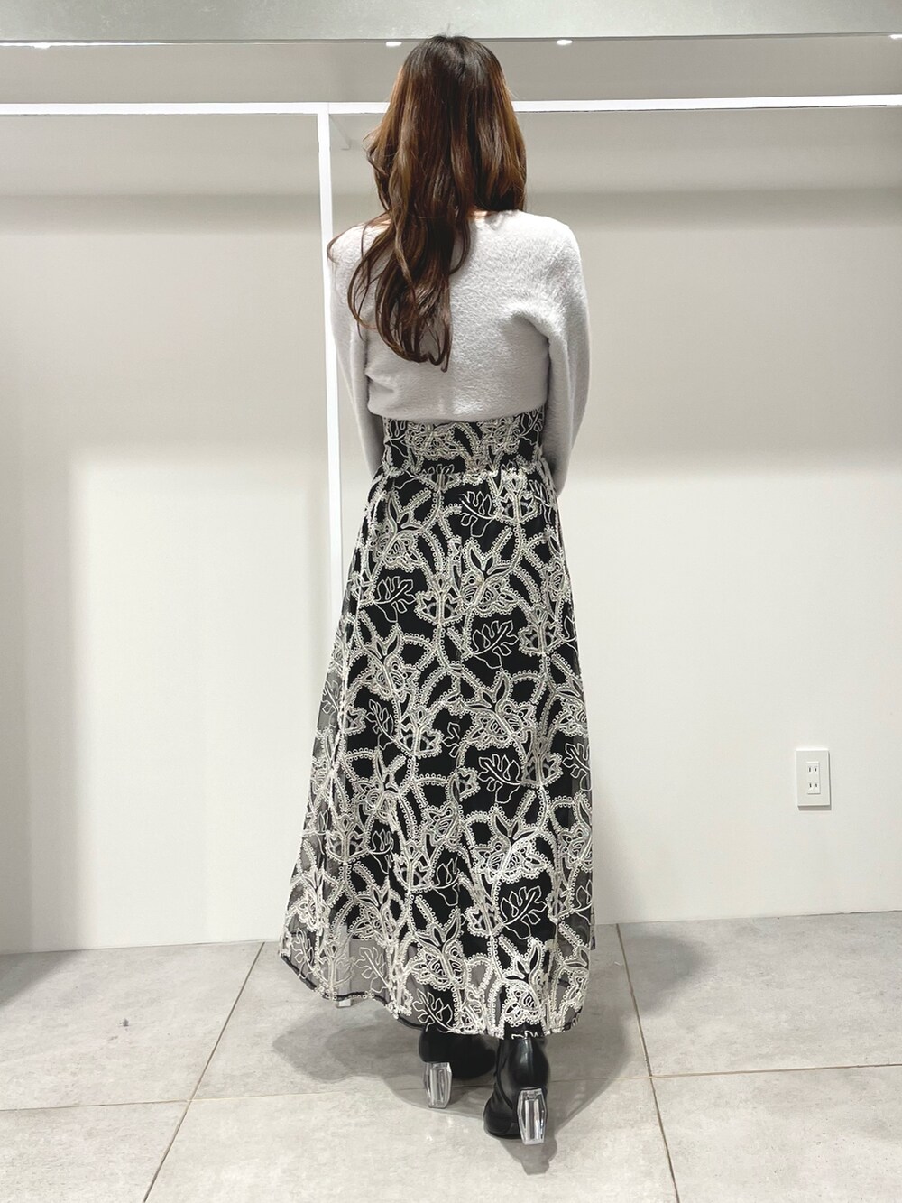 グレー系のカーディガン/ボレロ、ブラック系のスカート、ブラック系のブーツを着用したレディースの冬コーディネートの4枚目の写真