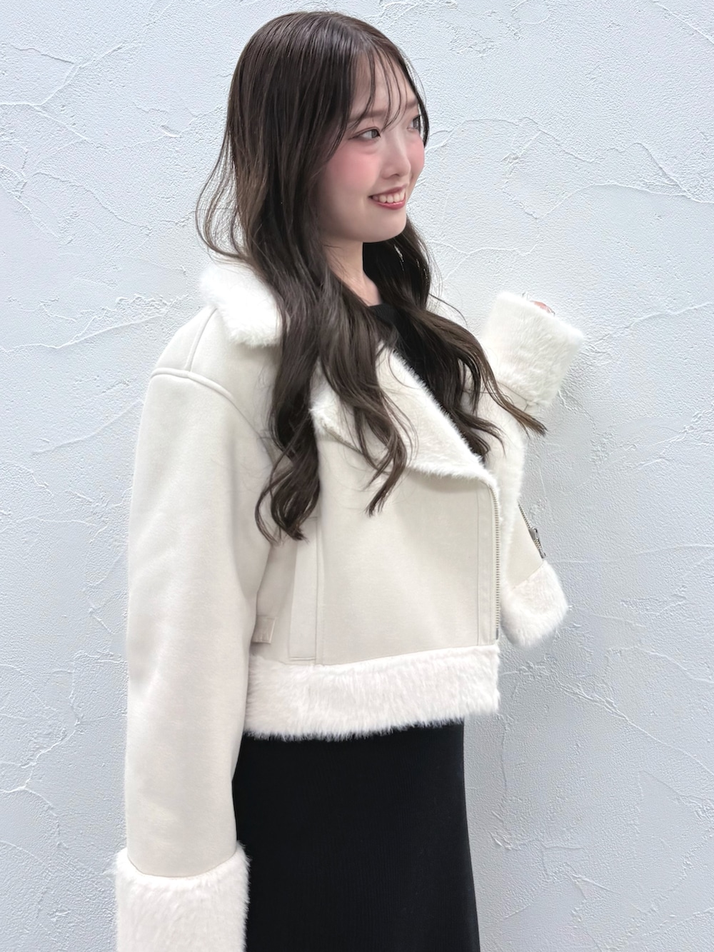 ブラック系のワンピース、ブラック系のブーツ、ホワイト系のムートンコートを着用したレディースの秋コーディネートの5枚目の写真