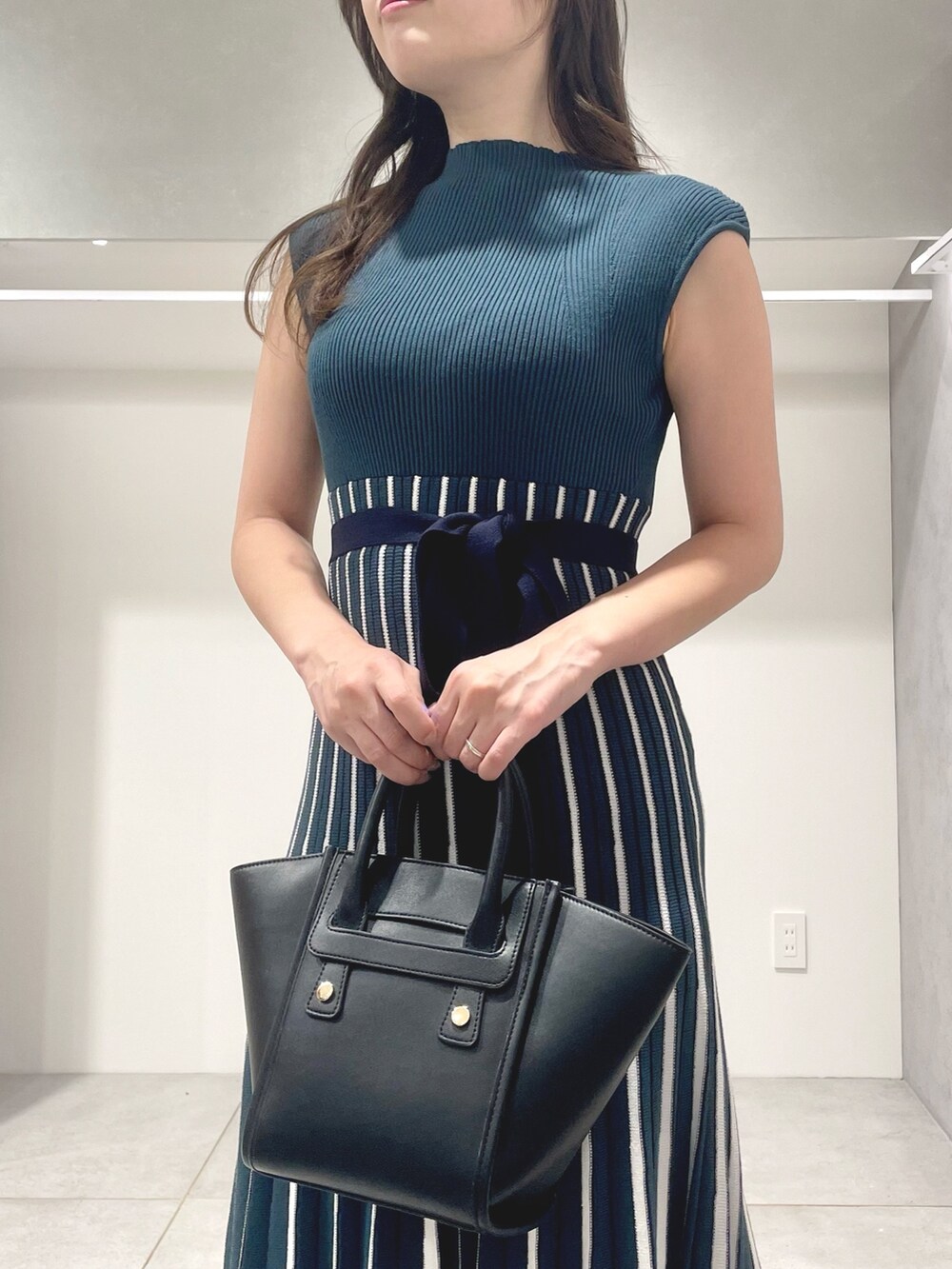 ブラック系のトートバッグ、ブラック系のサンダル、グリーン系のワンピースを着用したレディースの夏コーディネートの5枚目の写真