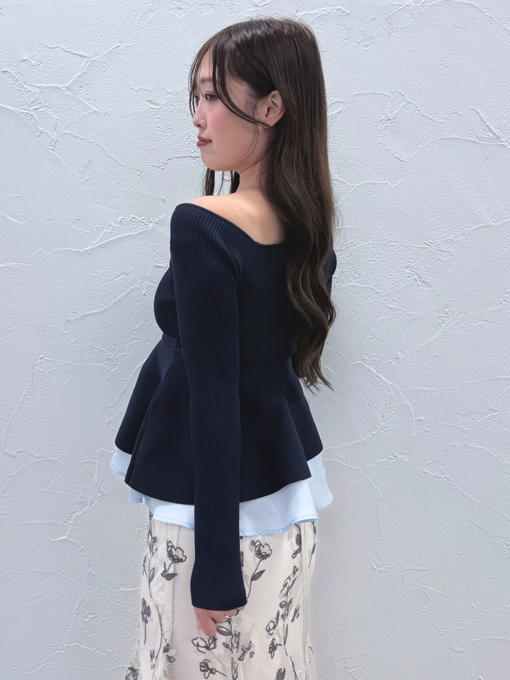 ブルー系のニット/セーター、ホワイト系のスカート、ブラック系のブーツを着用したレディースの秋コーディネートの6枚目の写真