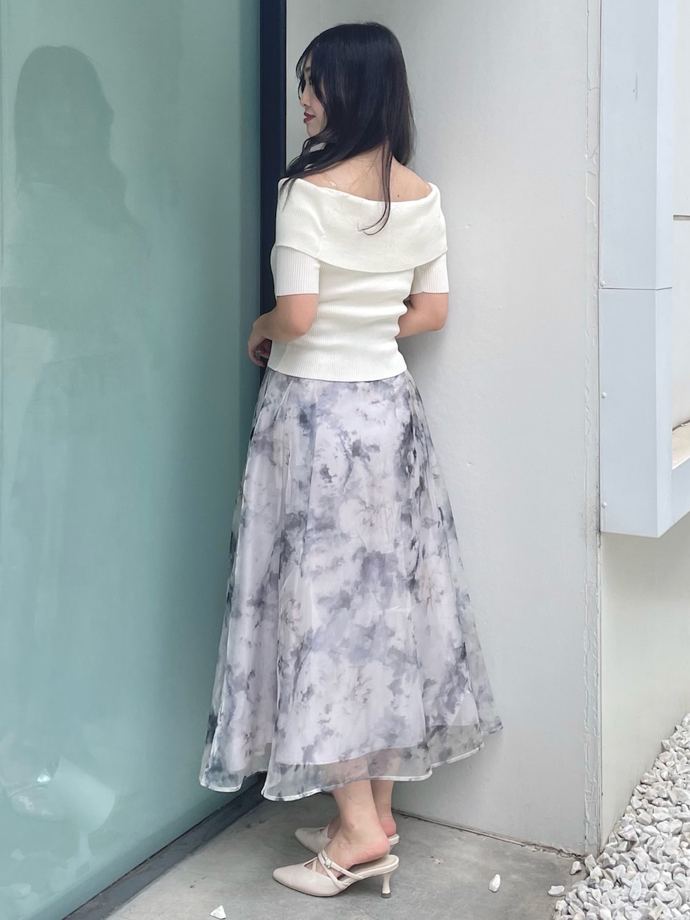 ホワイト系のニット/セーター、グレー系のスカート、ベージュ系のパンプスを着用したレディースの夏コーディネートの3枚目の写真