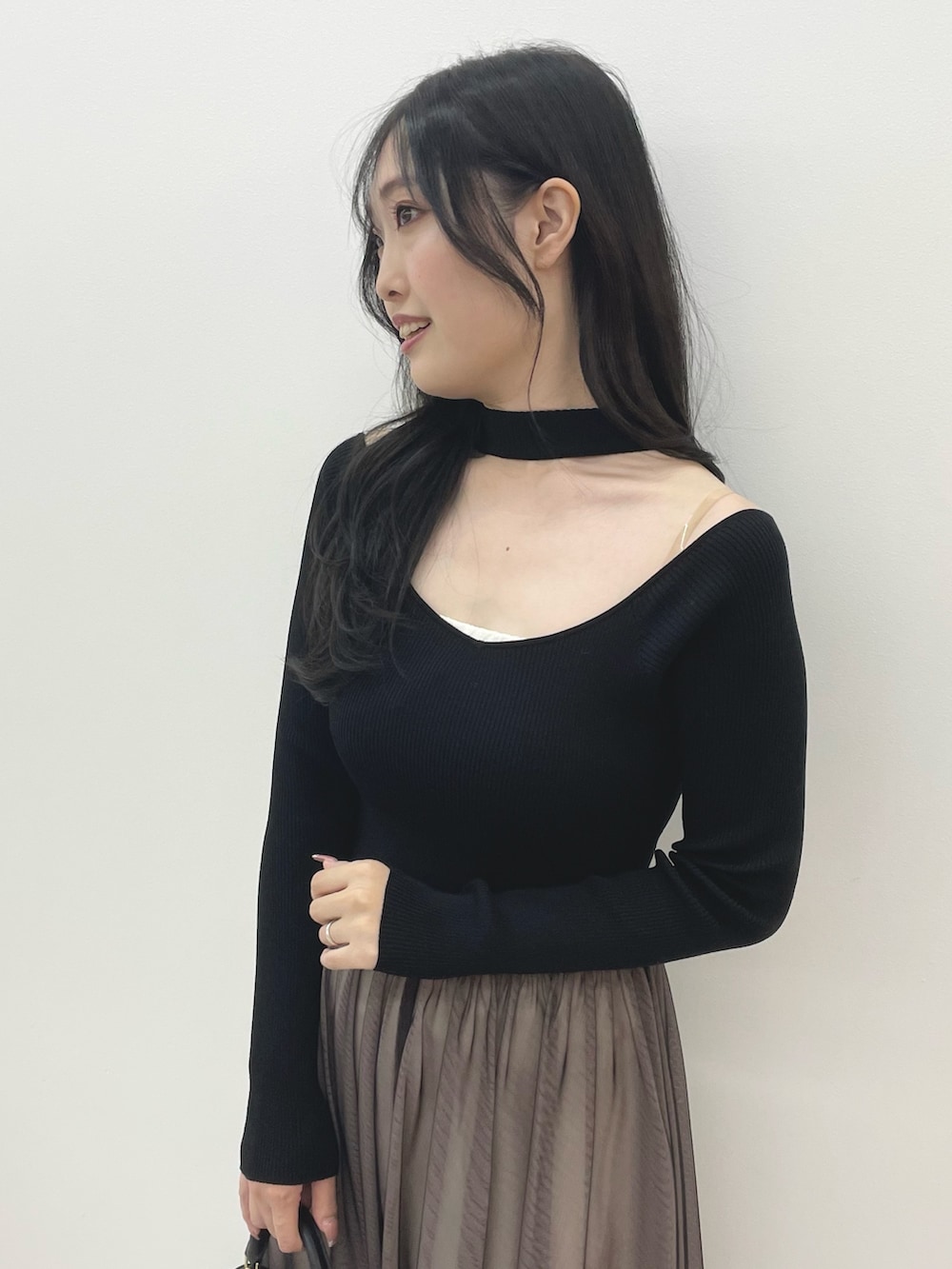 ブラック系のワンピース、ブラック系のハンドバッグ、ブラック系のブーツを着用したレディースの秋コーディネートの6枚目の写真