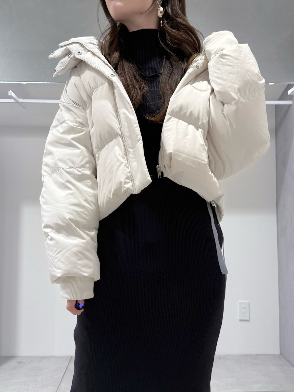 ホワイト系のダウンジャケット/コート、ブルー系のワンピース、ブラック系のブーツを着用したレディースの冬コーディネートの4枚目の写真