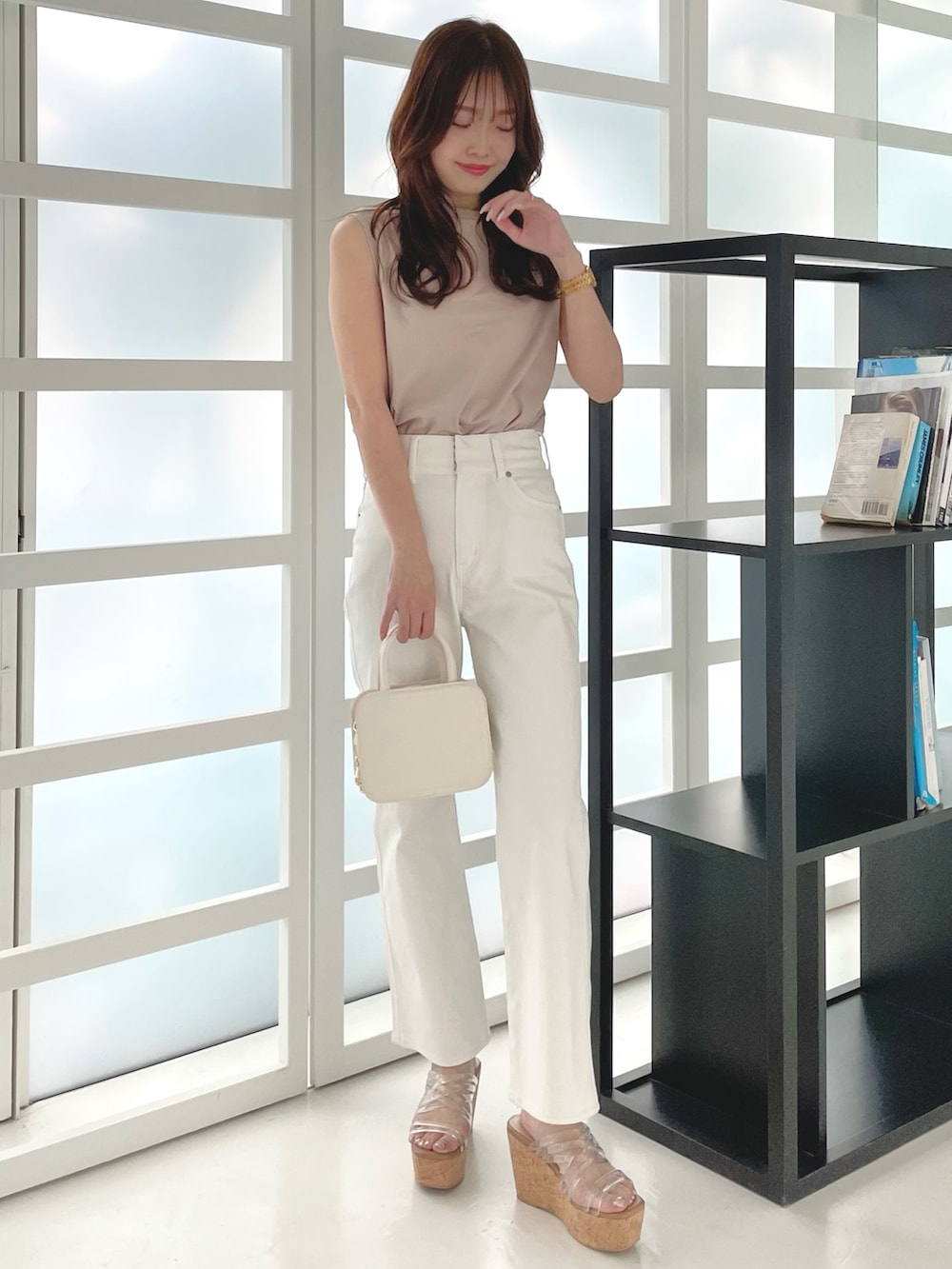 ホワイト系のデニムパンツ、その他のサンダル、ホワイト系のハンドバッグを着用したレディースの春コーディネートの2枚目の写真