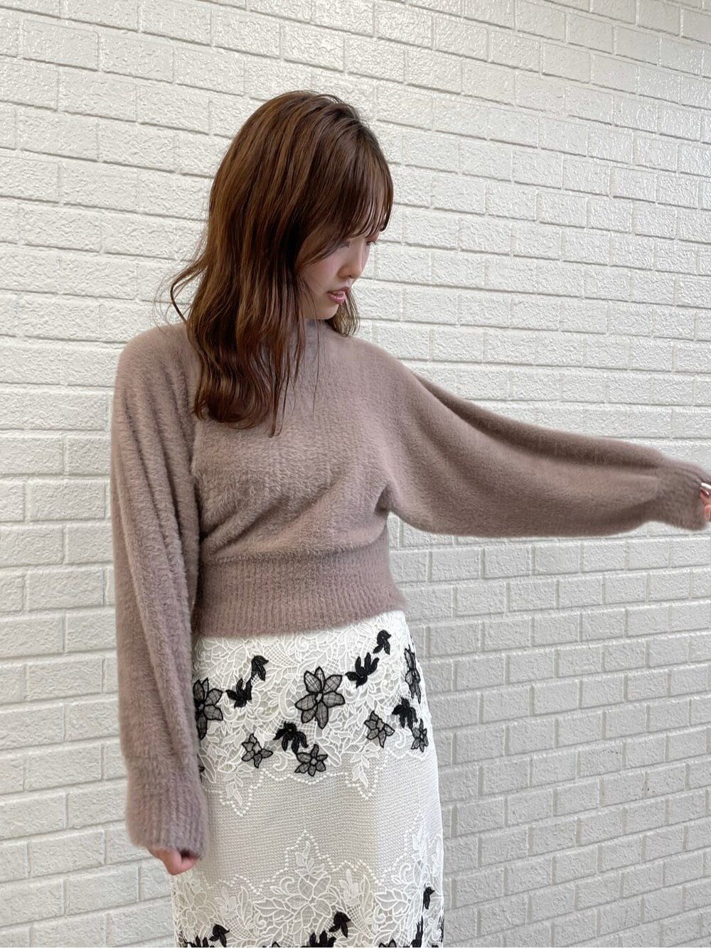 ブラウン系のニット/セーター、ホワイト系のスカート、ホワイト系のその他シューズを着用したレディースの秋コーディネートの4枚目の写真
