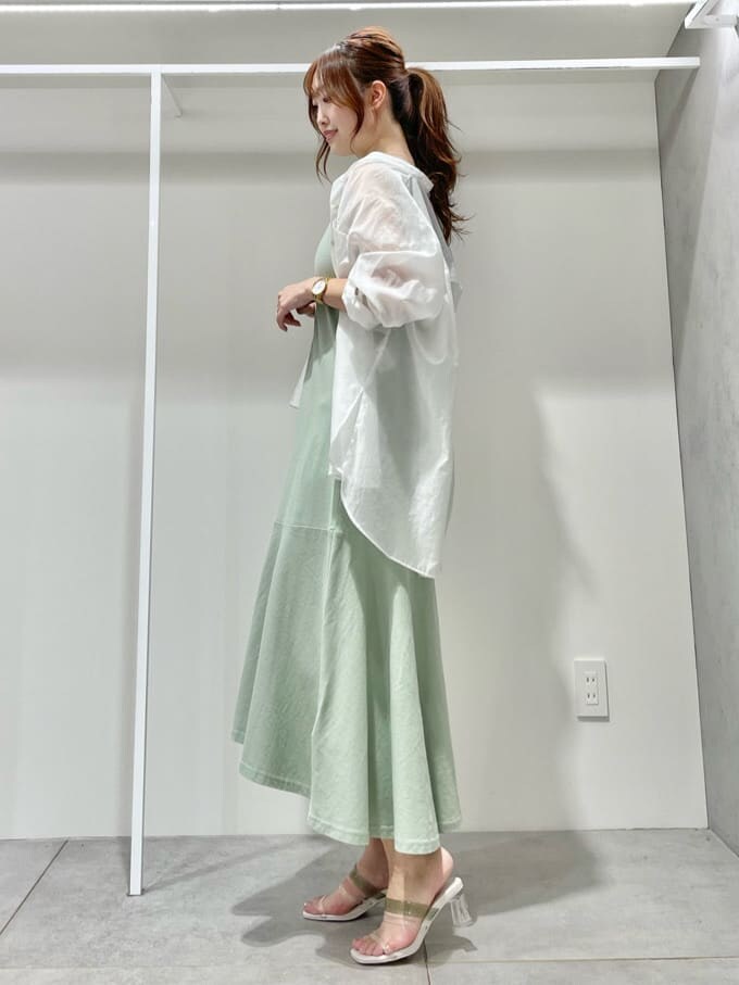 グリーン系のサンダル、ホワイト系のシャツ/ブラウス、ブラック系のキャミソールを着用したレディースの夏コーディネートの2枚目の写真