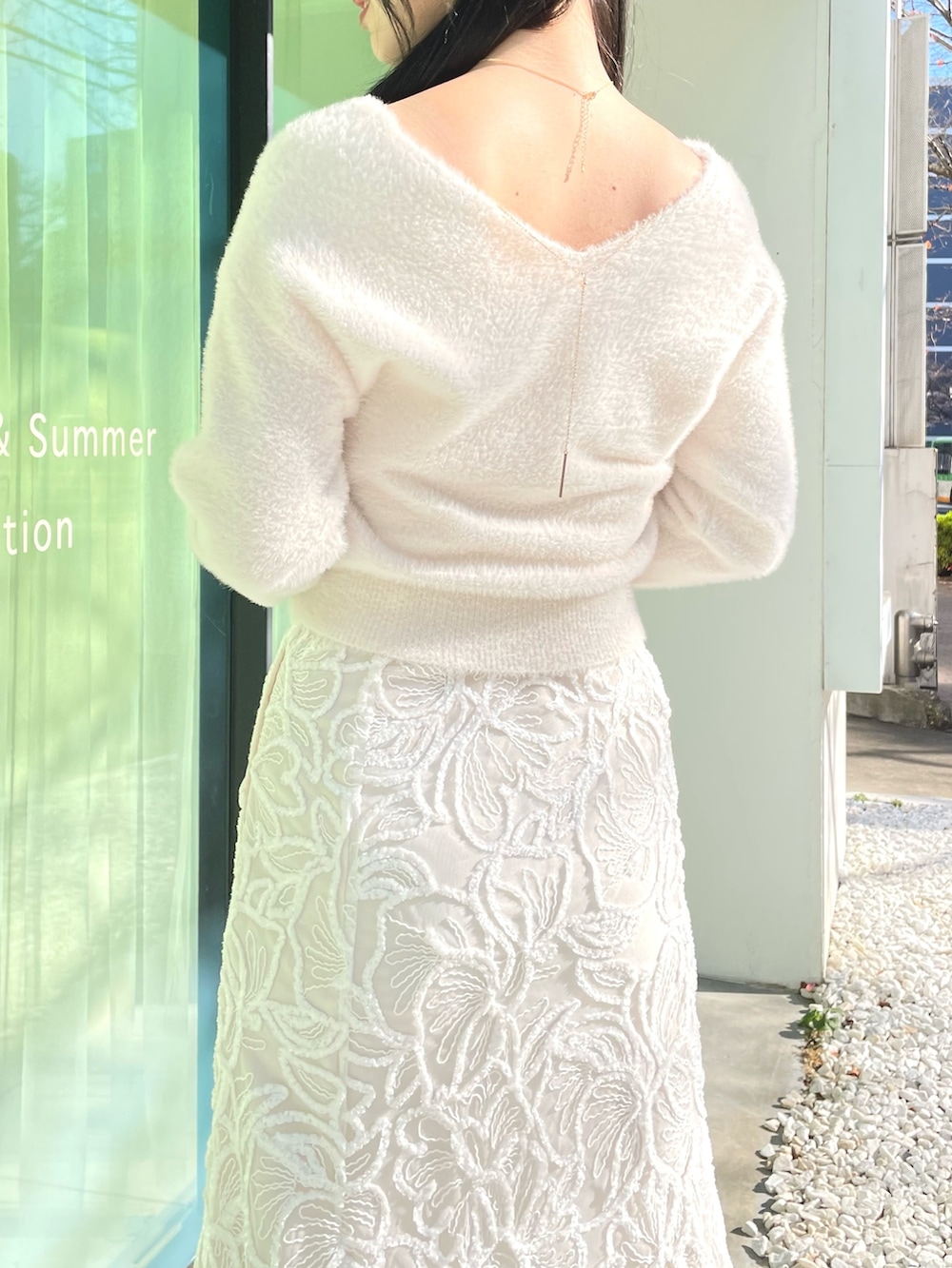 ホワイト系のダウンジャケット/コート、ホワイト系のニット/セーター、ホワイト系のスカートを着用したレディースの冬コーディネートの8枚目の写真