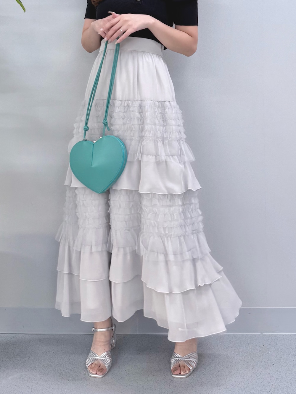 ブルー系のニット/セーター、グレー系のスカート、グリーン系のショルダーバッグを着用したレディースの夏コーディネートの6枚目の写真