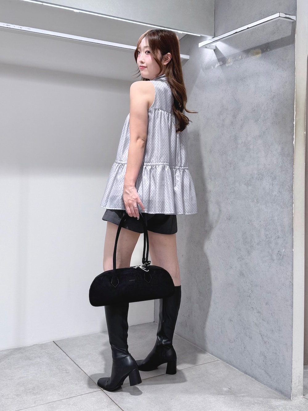 グレー系のシャツ/ブラウス、ブラック系のハンドバッグ、ブラック系のブーツを着用したレディースの夏コーディネートの3枚目の写真