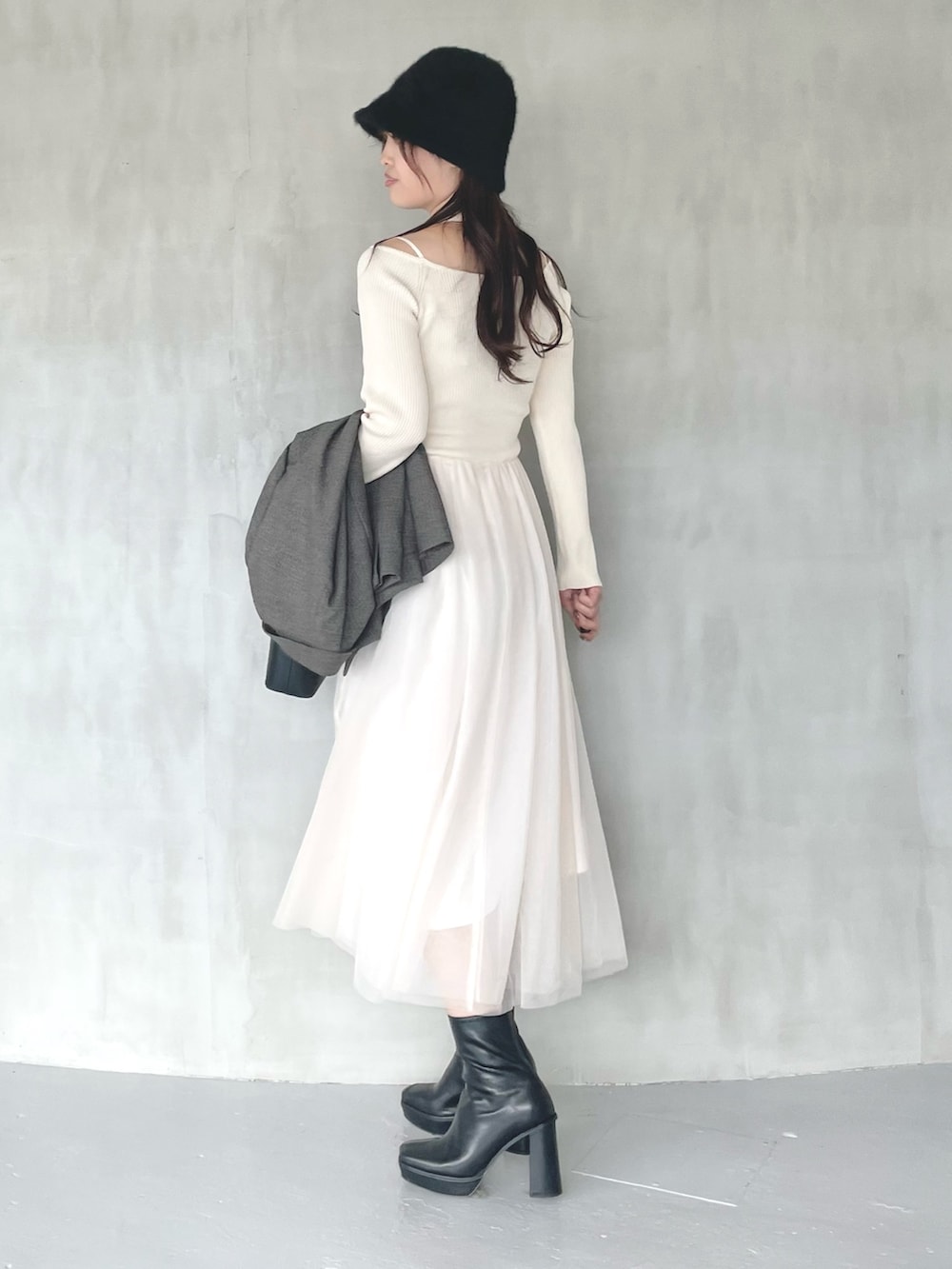 ブラック系のブーツ、ブラウン系のテーラードジャケット、ブラック系のハンドバッグを着用したレディースの秋コーディネートの2枚目の写真