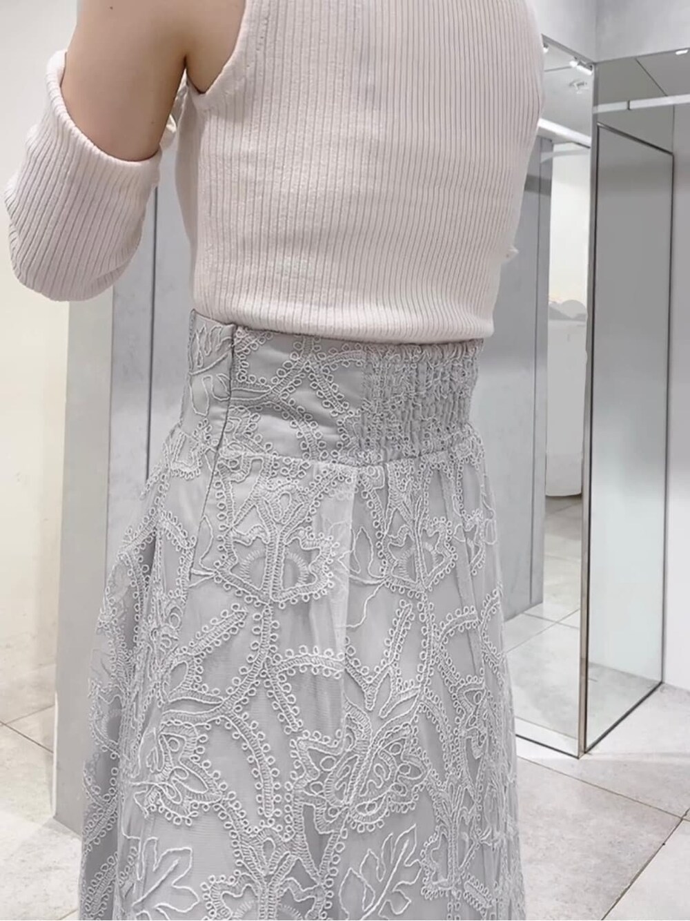 グリーン系のスカート、グリーン系のサンダル、ホワイト系のニット/セーターを着用したレディースの夏コーディネートの4枚目の写真