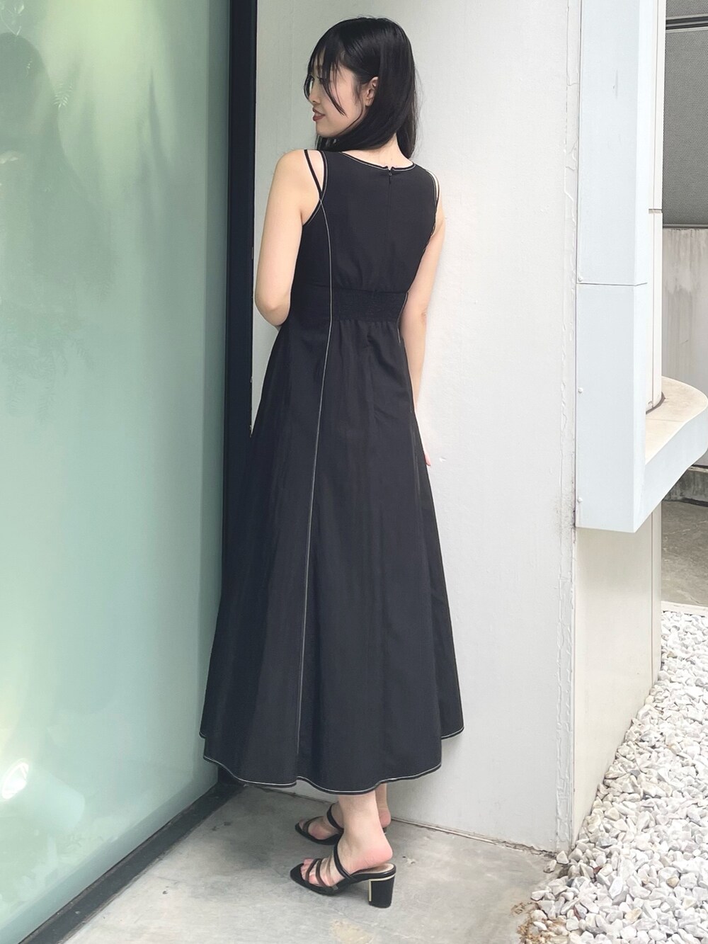 ブラック系のワンピース、ブラック系のサンダルを着用したレディースの夏コーディネートの3枚目の写真