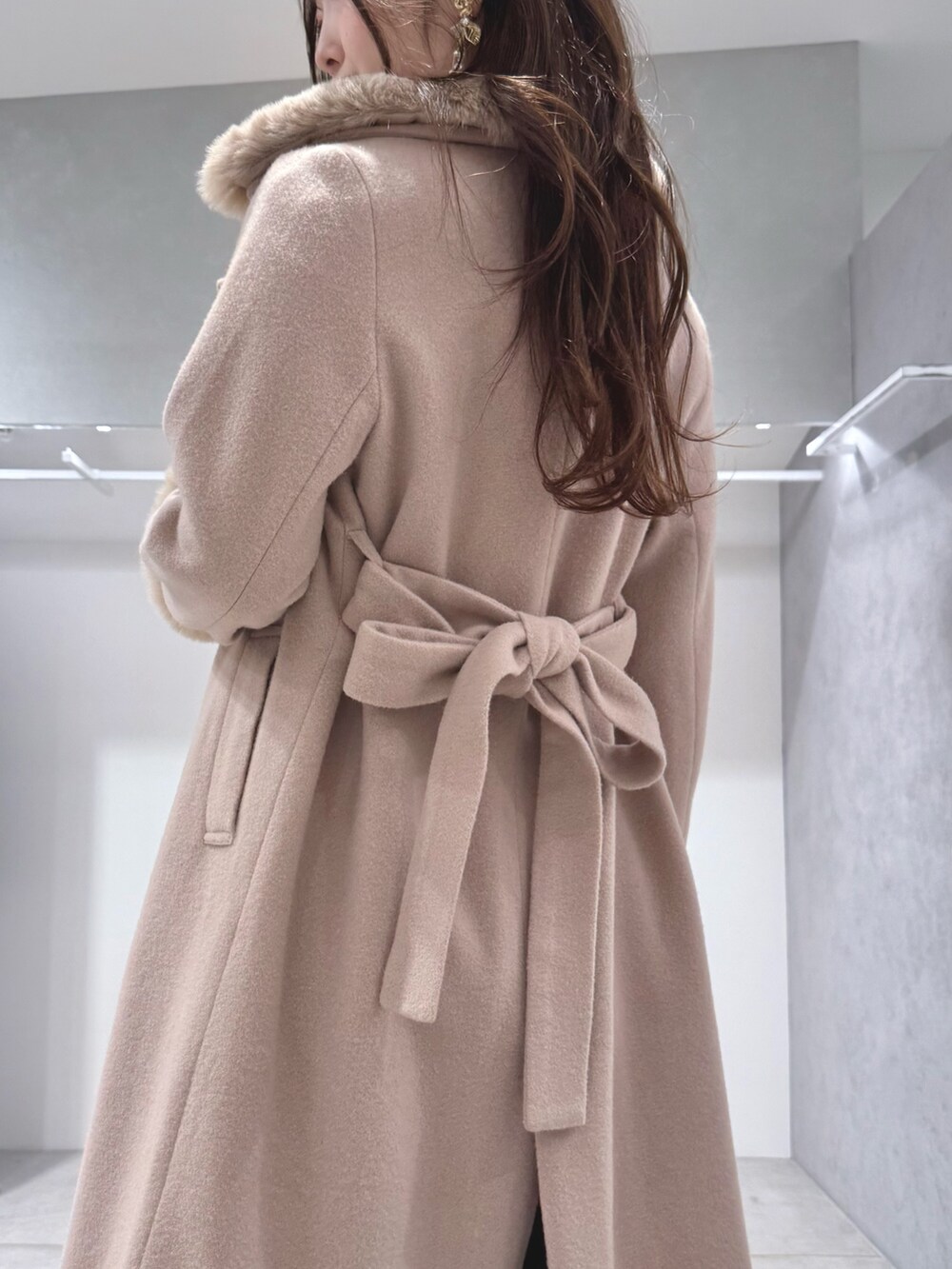 ベージュ系のその他アウター、ホワイト系のハンドバッグ、ブラック系のワンピースを着用したレディースの冬コーディネートの6枚目の写真