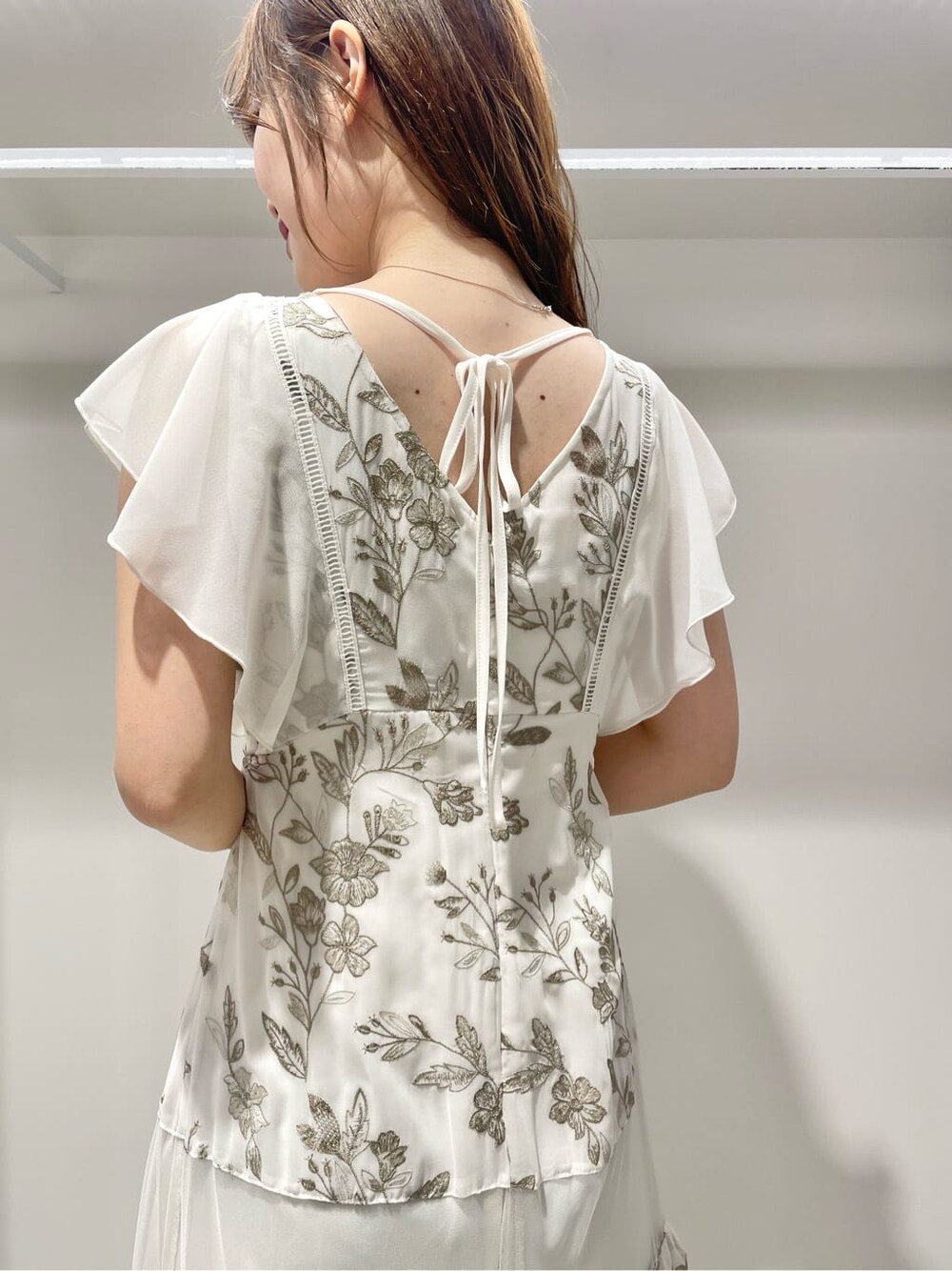 ブルー系のテーラードジャケット、ベージュ系のワンピースを着用したレディースの春コーディネートの10枚目の写真