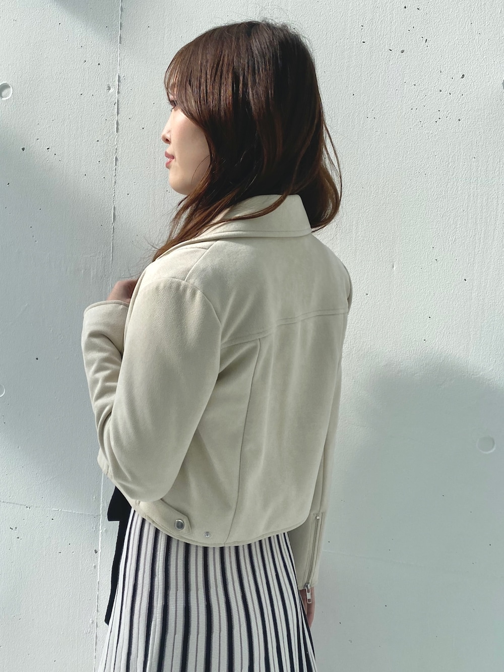 ホワイト系のワンピース、ベージュ系のライダースジャケットを着用したレディースの春コーディネートの5枚目の写真