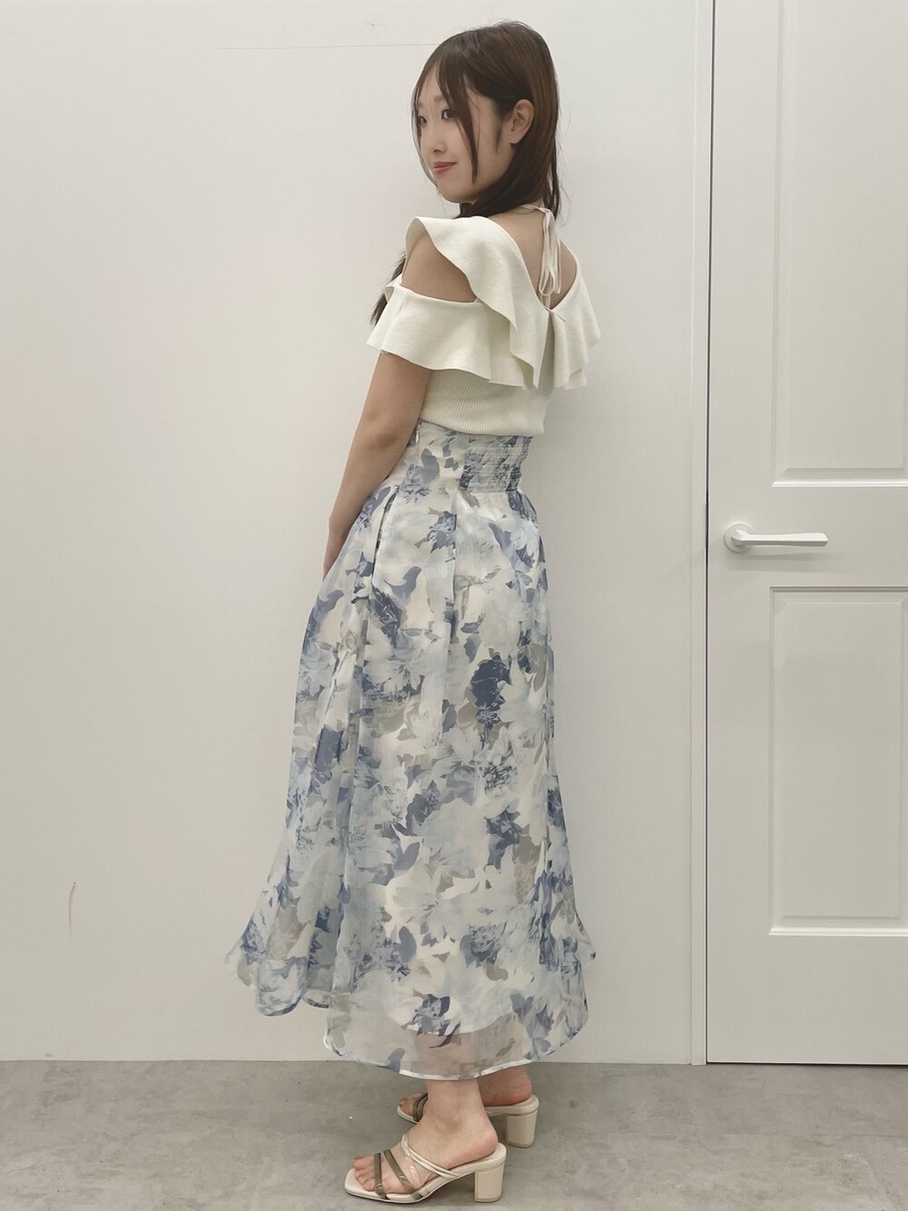 ホワイト系のニット/セーター、ブルー系のスカート、ホワイト系のサンダルを着用したレディースの夏コーディネートの3枚目の写真