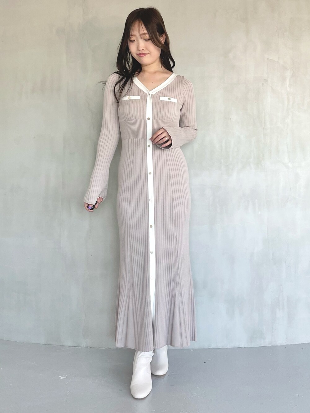 ベージュ系のトレンチコート、ピンク系のワンピース、ホワイト系のブーツを着用したレディースの冬コーディネートの5枚目の写真