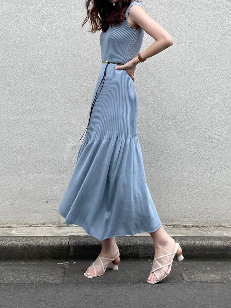 ホワイト系のクラッチバッグ、ブルー系のワンピース、ベージュ系のサンダルを着用したレディースの夏コーディネートの3枚目の写真