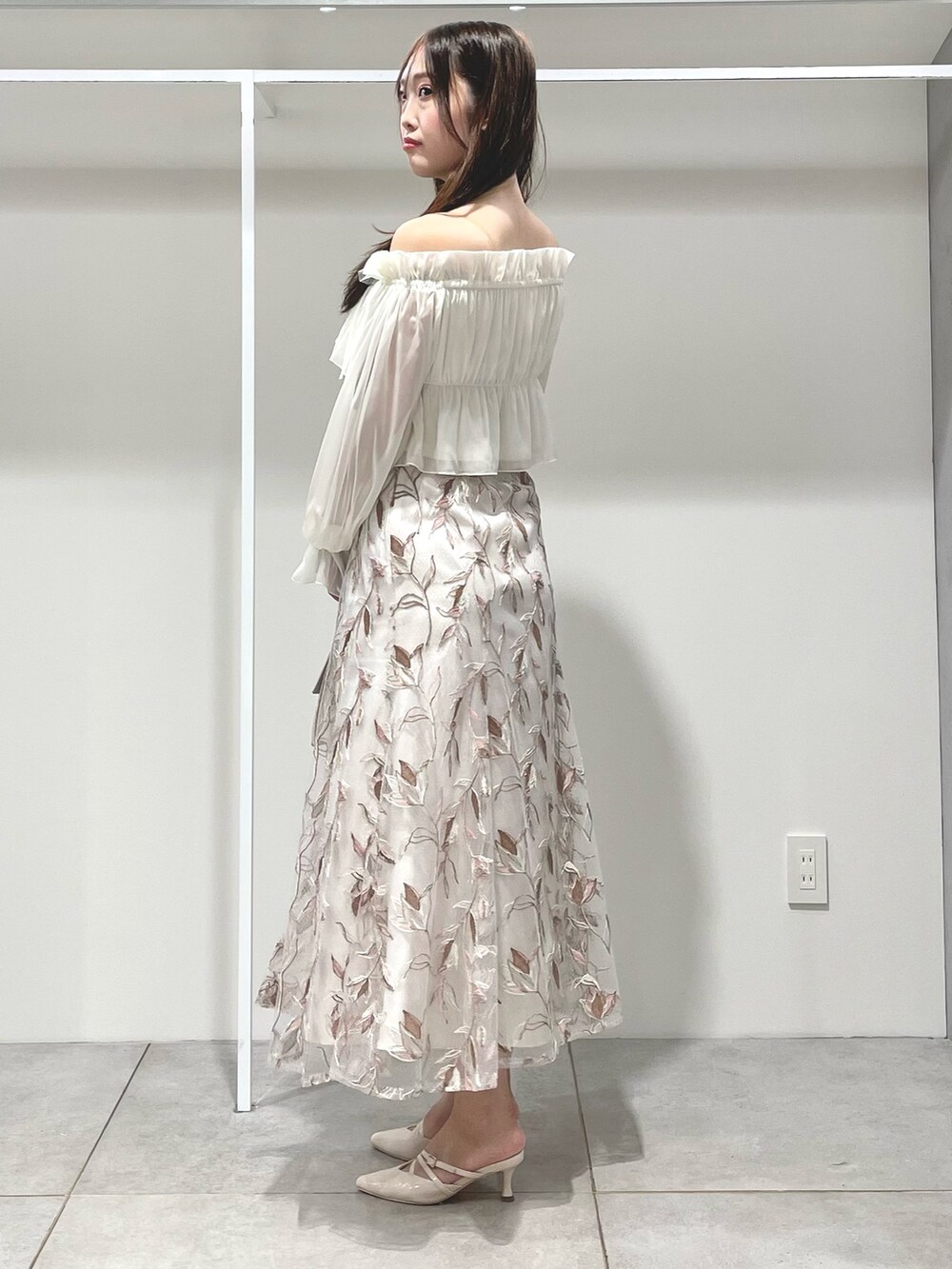 ホワイト系のシャツ/ブラウス、ピンク系のスカート、ベージュ系のパンプスを着用したレディースの夏コーディネートの2枚目の写真