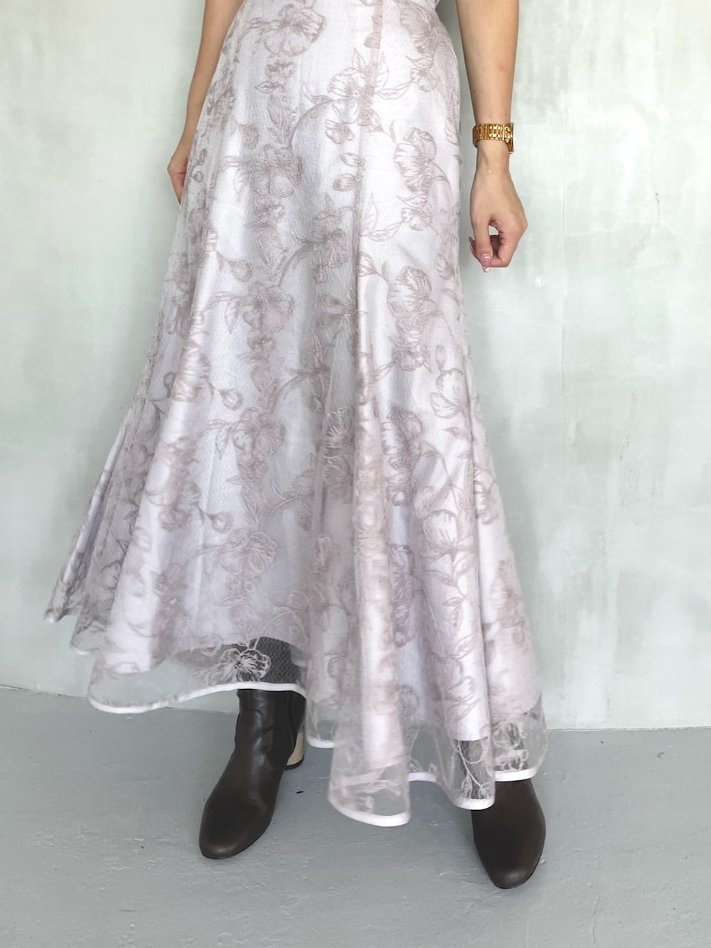 ピンク系のニット/セーター、ピンク系のスカート、ブラウン系のブーツを着用したレディースの春コーディネートの6枚目の写真