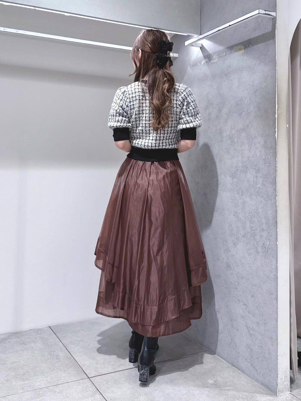 ブラック系のカーディガン/ボレロ、ブラウン系のスカート、ゴールド系のショルダーバッグを着用したレディースの秋コーディネートの4枚目の写真