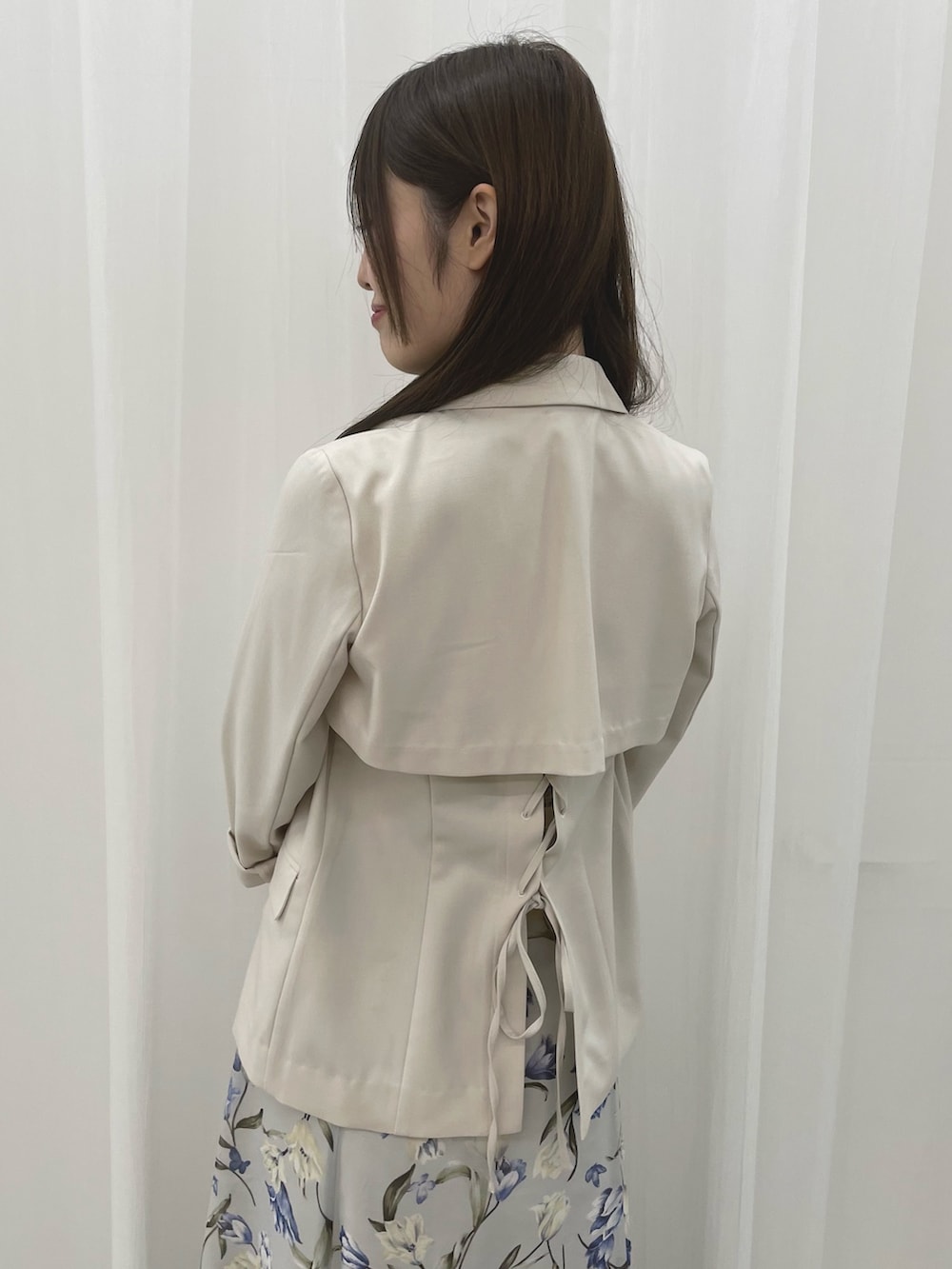 ブルー系のワンピース、ホワイト系のテーラードジャケット、ホワイト系のパンプスを着用したレディースの春コーディネートの5枚目の写真