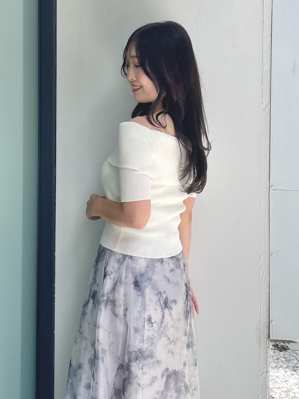 ホワイト系のニット/セーター、グレー系のスカート、ベージュ系のパンプスを着用したレディースの夏コーディネートの6枚目の写真