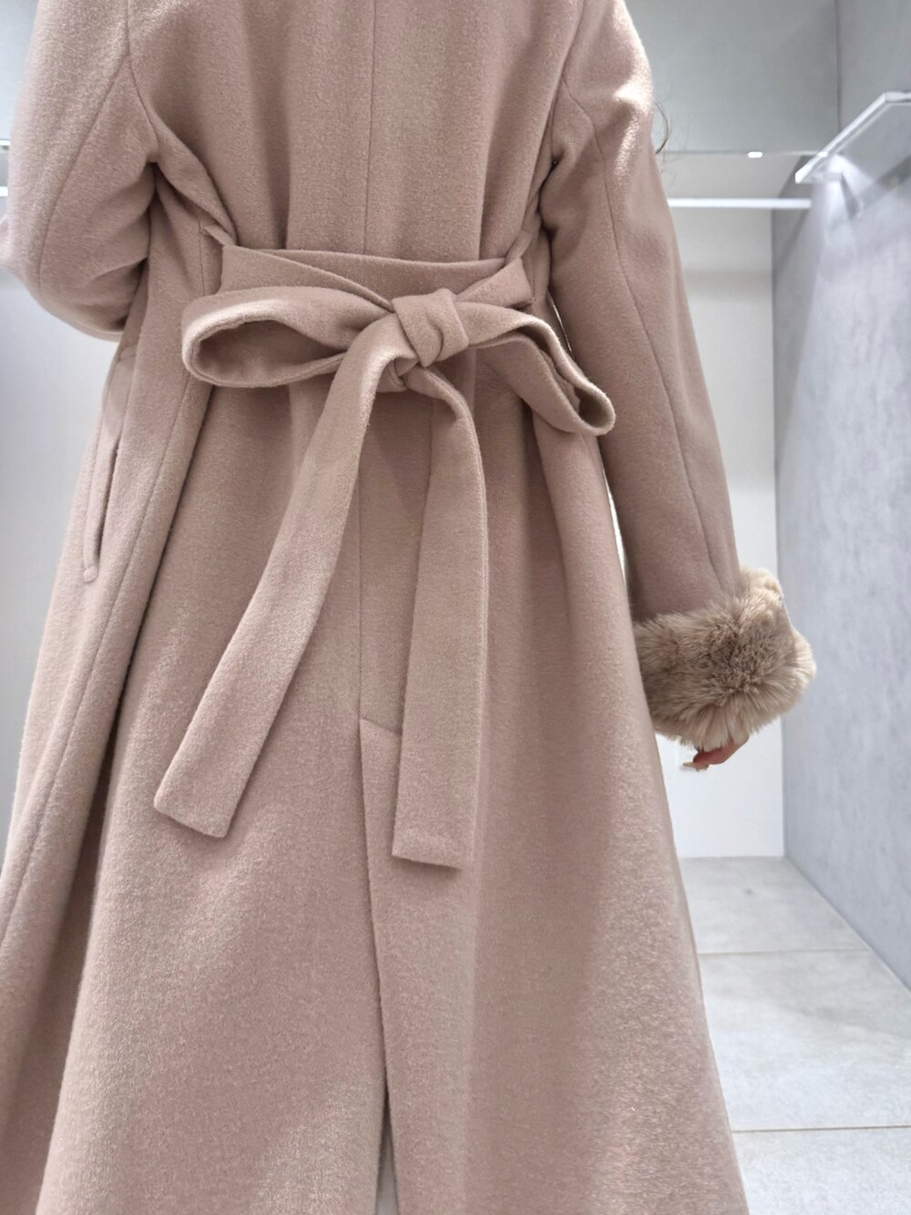 ベージュ系のその他アウター、ホワイト系のワンピース、ホワイト系のブーツを着用したレディースの冬コーディネートの5枚目の写真