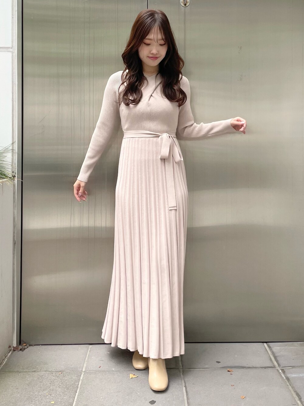 ホワイト系のステンカラーコート、ベージュ系のワンピース、ベージュ系のブーツを着用したレディースの秋コーディネートの6枚目の写真