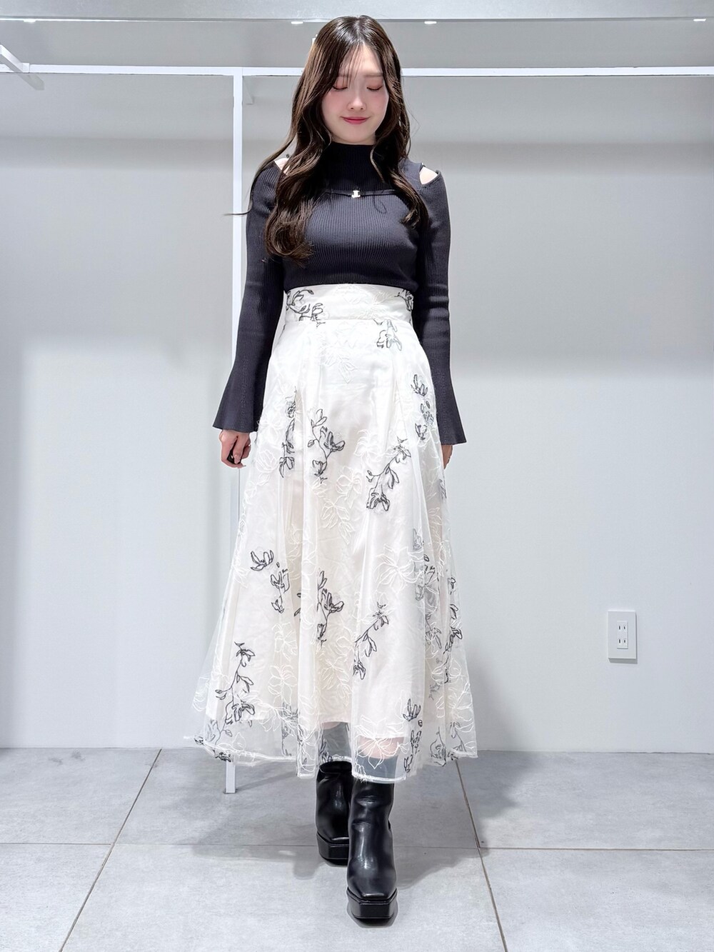 グレー系のその他アウター、グレー系のニット/セーター、ホワイト系のスカートを着用したレディースの冬コーディネートの7枚目の写真