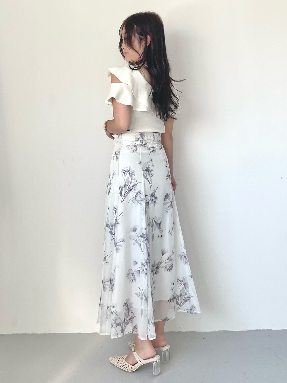 ホワイト系のスカート、パープル系のトレンチコート、ホワイト系のニット/セーターを着用したレディースの冬コーディネートの7枚目の写真