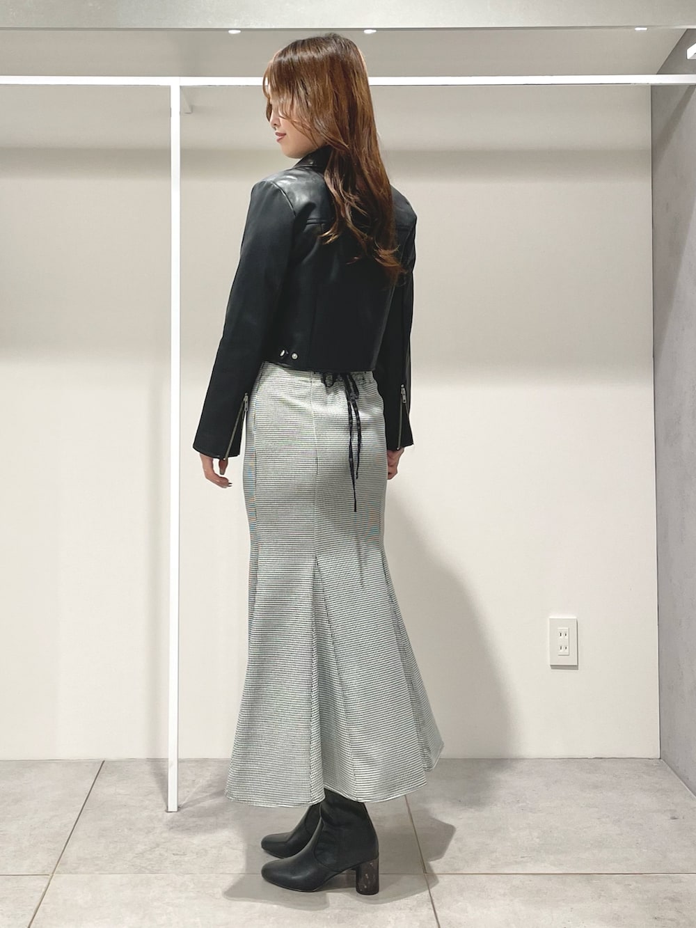 ブラック系のライダースジャケット、ブラック系のニット/セーター、その他のスカートを着用したレディースの秋コーディネートの2枚目の写真