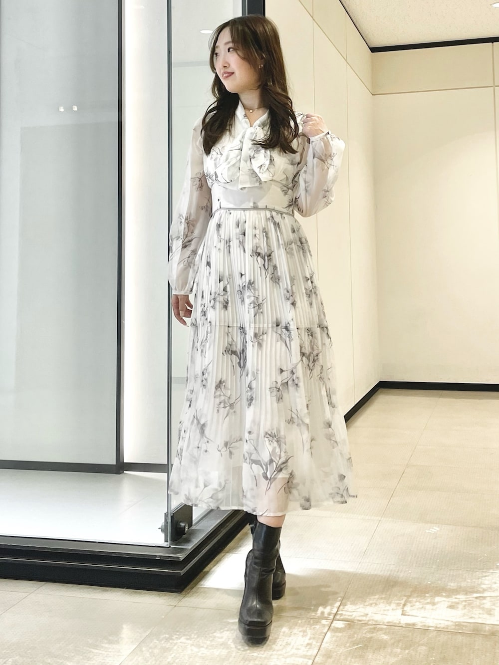 ホワイト系のワンピース、ブラック系のブーツを着用したレディースの冬コーディネートの2枚目の写真