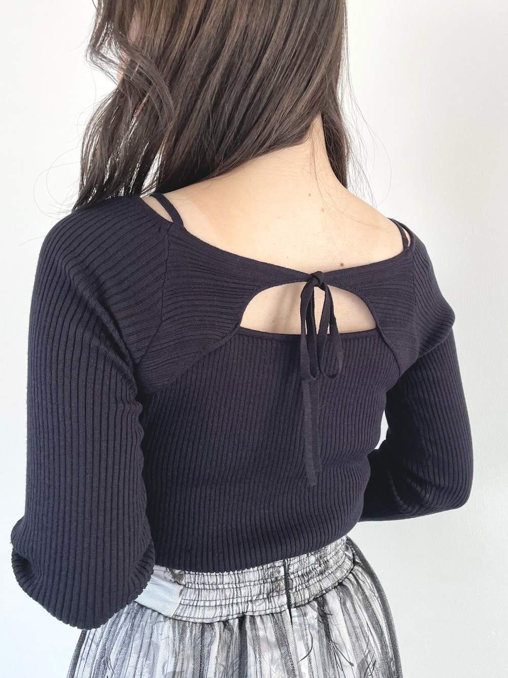 ブラック系のブーツ、ブラック系のスカート、ブラック系のハンドバッグを着用したレディースの春コーディネートの7枚目の写真