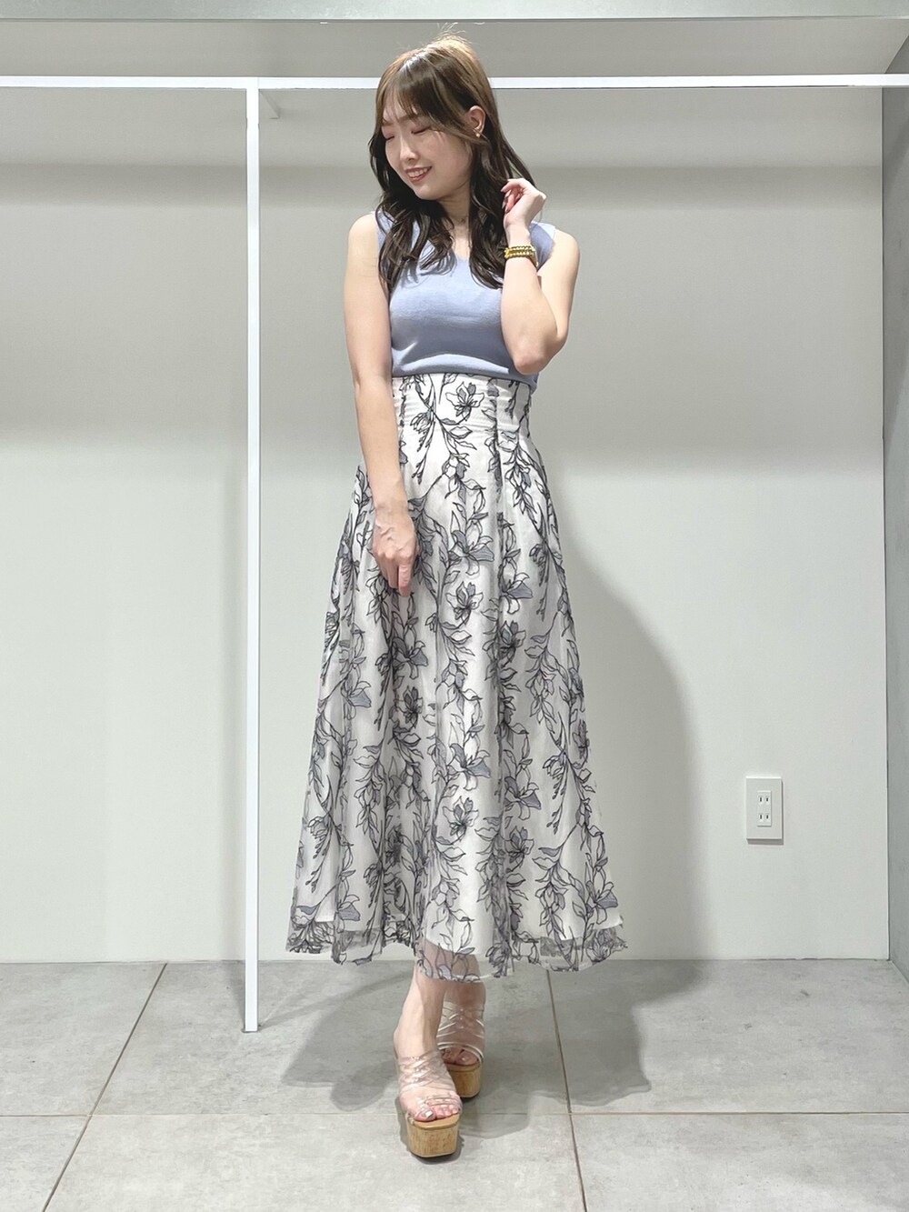 ブルー系のニット/セーター、グレー系のスカート、その他のサンダルを着用したレディースの春コーディネートの2枚目の写真