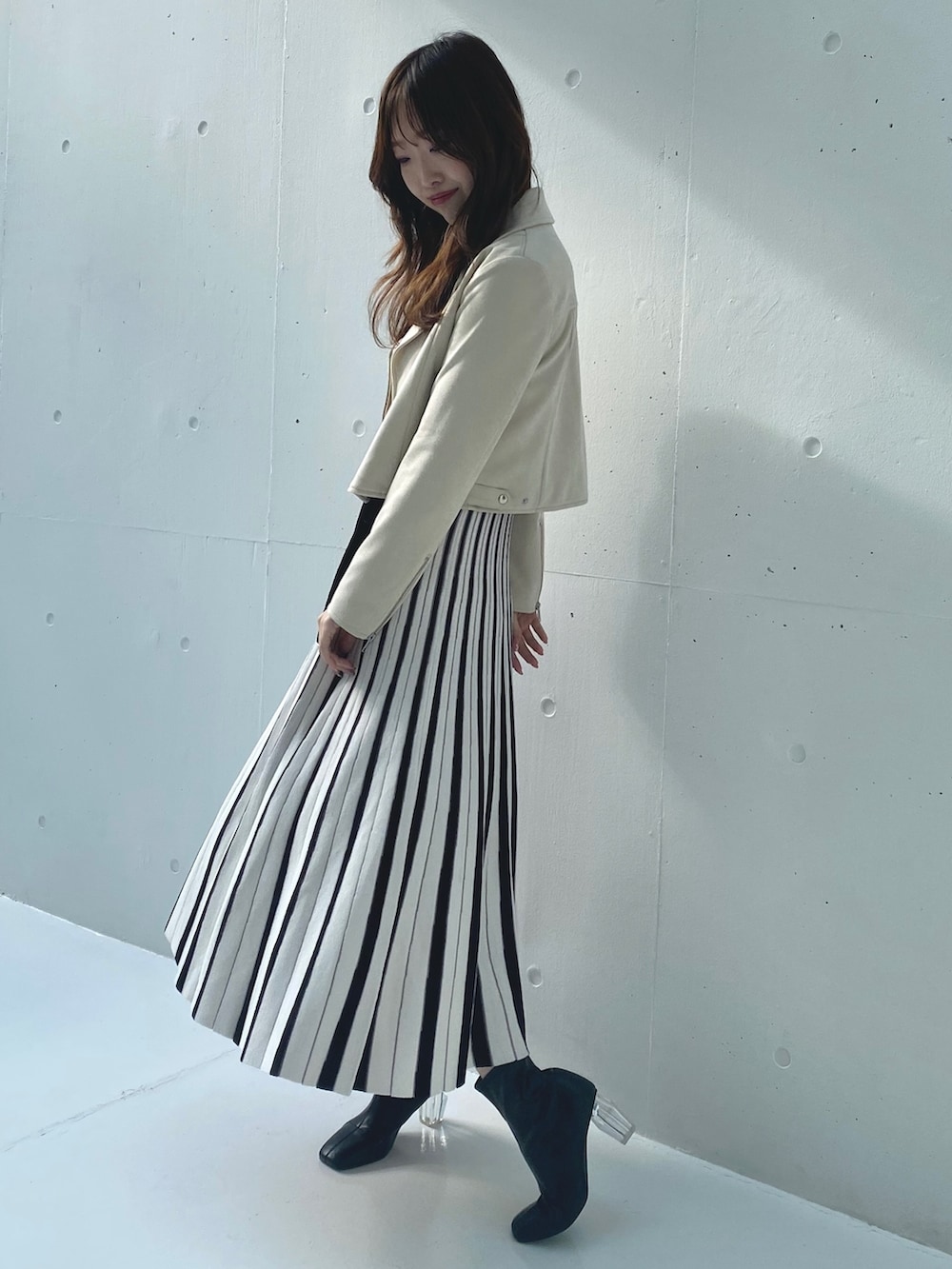 ホワイト系のワンピース、ベージュ系のライダースジャケットを着用したレディースの春コーディネートの2枚目の写真