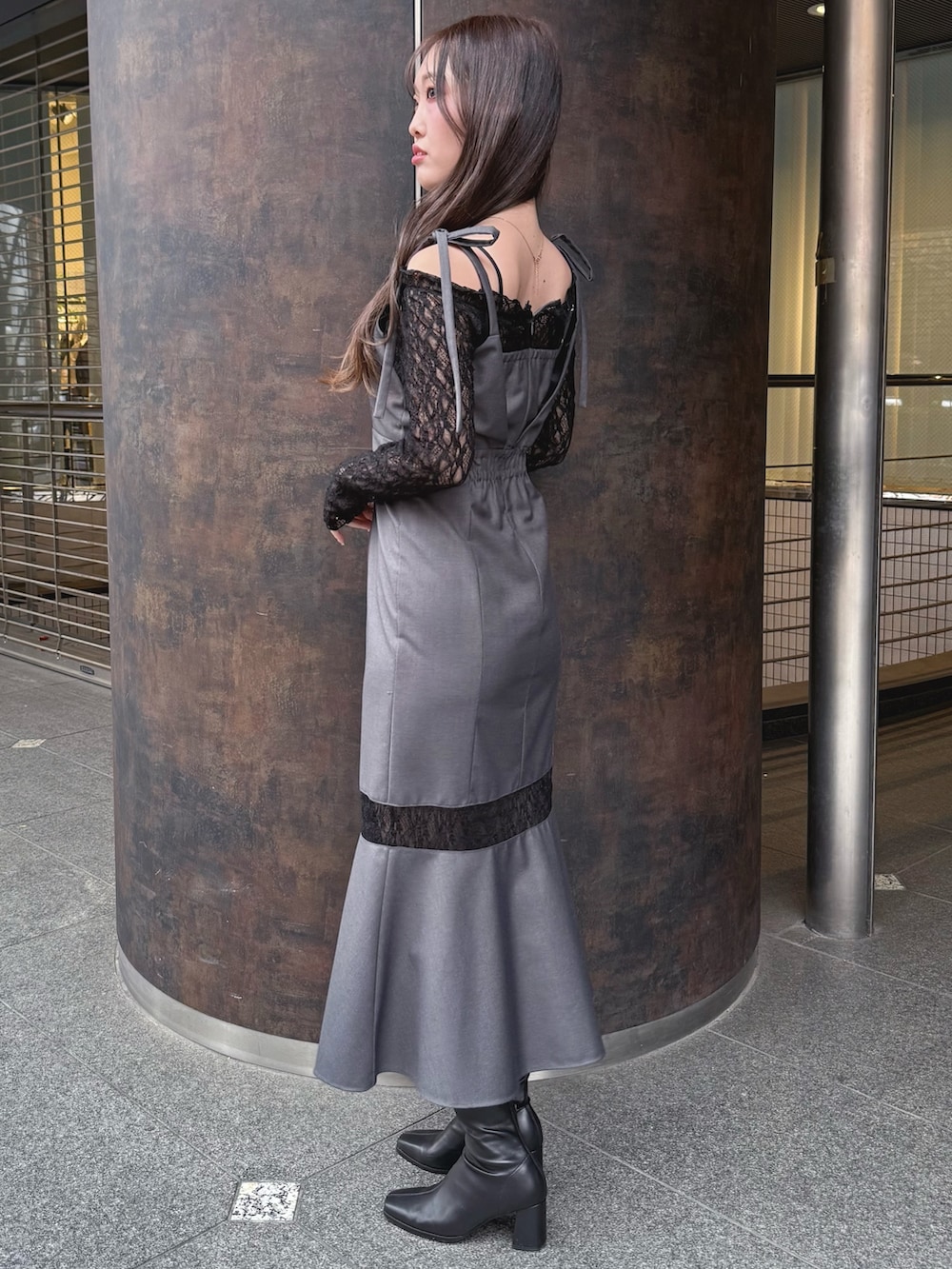 グレー系のワンピース、ブラック系のブーツを着用したレディースの秋コーディネートの2枚目の写真