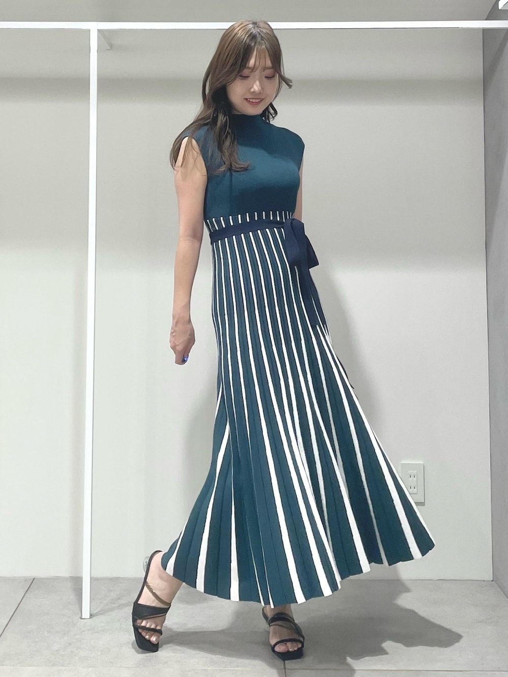 ブラック系のトートバッグ、ブラック系のサンダル、グリーン系のワンピースを着用したレディースの夏コーディネートの4枚目の写真