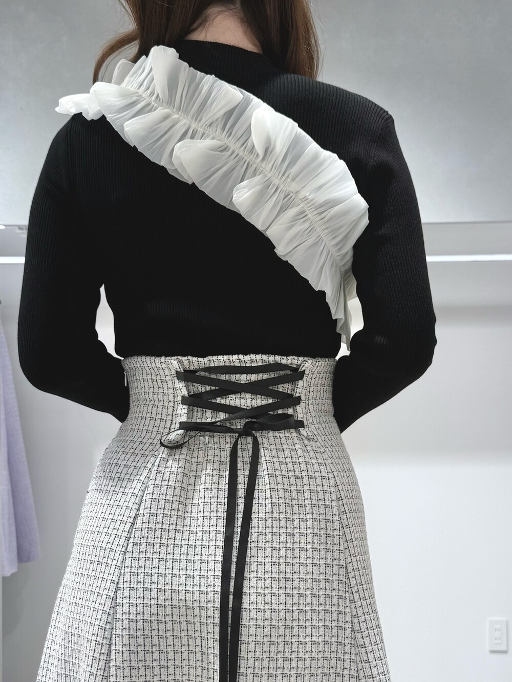 ブラック系のニット/セーター、ブラック系のハンドバッグ、ブラック系のブーツを着用したレディースの秋コーディネートの7枚目の写真