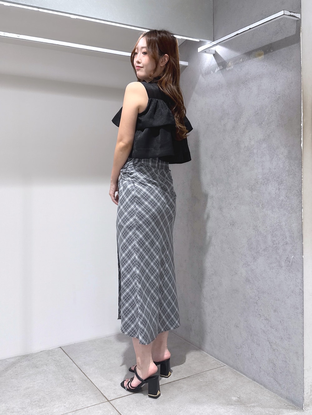 ブラック系のシャツ/ブラウス、ブラック系のスカート、ブラック系のサンダルを着用したレディースの夏コーディネートの2枚目の写真