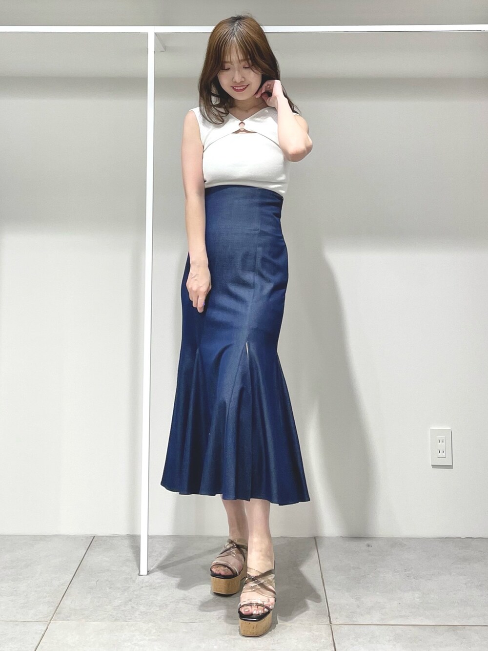 ブルー系のスカート、ブラック系のサンダル、ベージュ系のシャツ/ブラウスを着用したレディースの春コーディネートの6枚目の写真