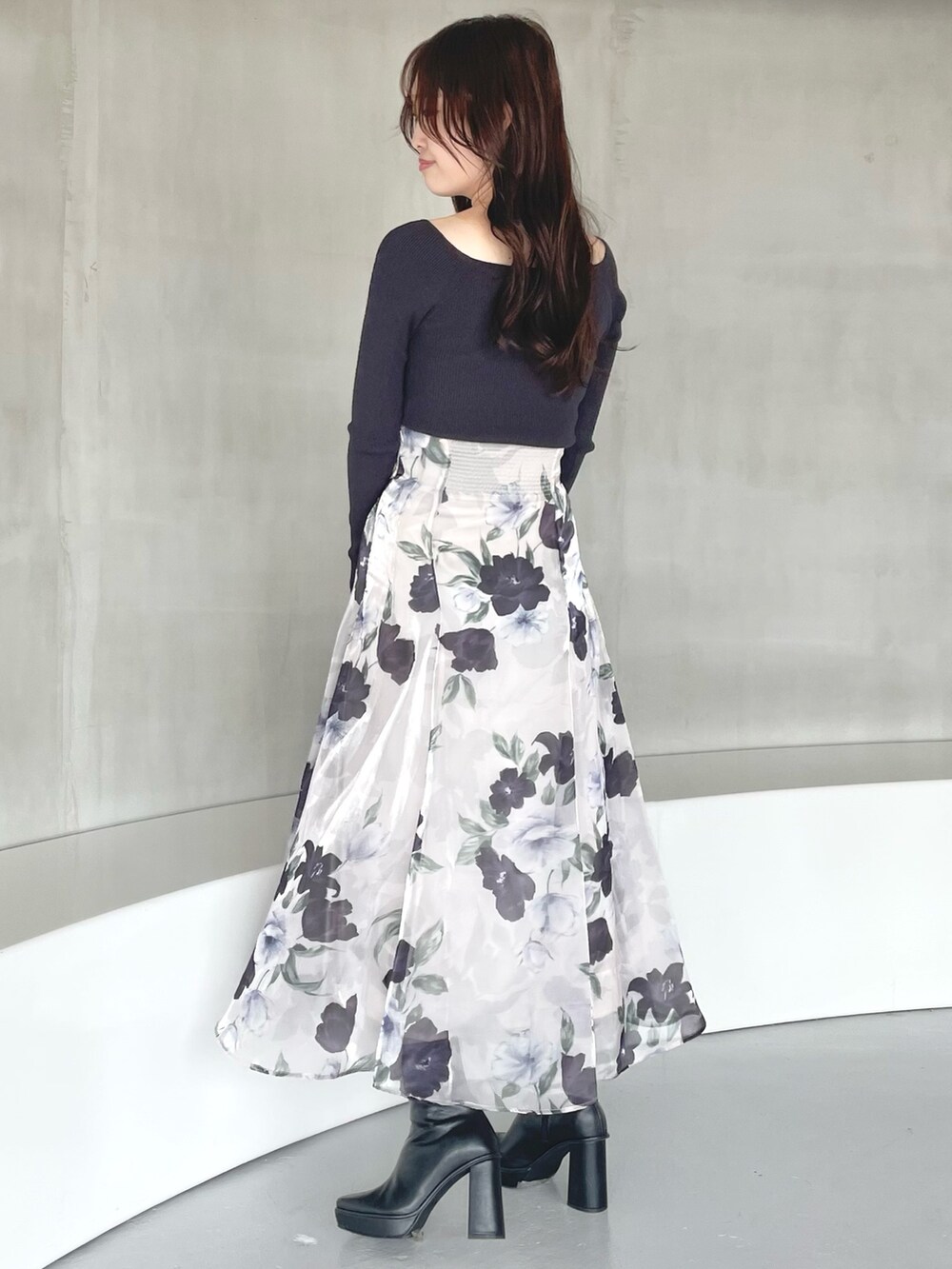 ブルー系のスカート、ブラック系のブーツ、グレー系のニット/セーターを着用したレディースの秋コーディネートの2枚目の写真