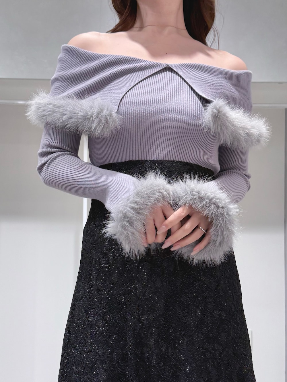 グレー系のニット/セーター、ブラック系のスカート、ブラック系のショルダーバッグを着用したレディースの冬コーディネートの4枚目の写真